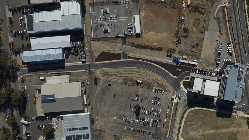 An aerial image shows the new road near builds and carparks.